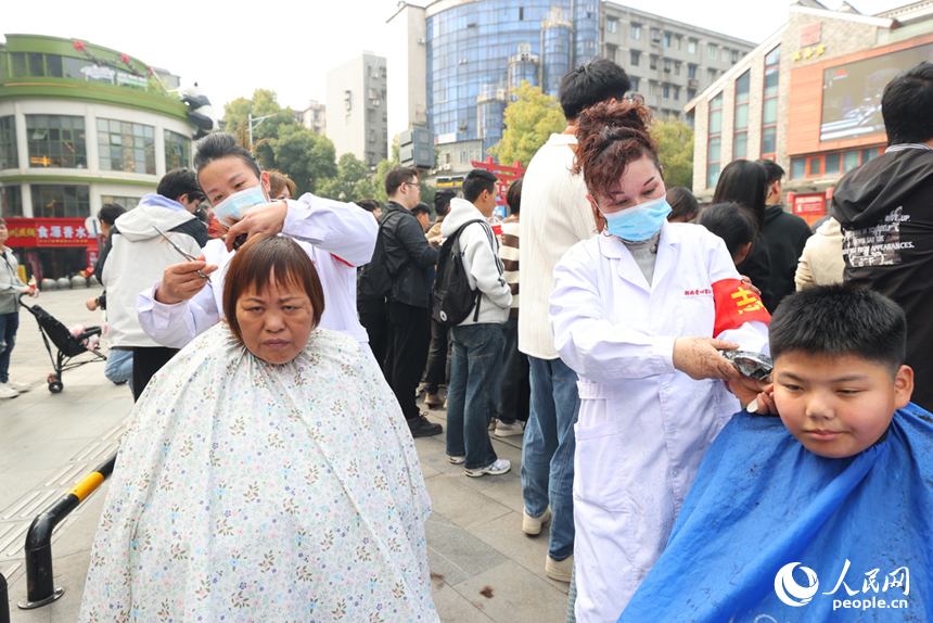 志愿者们现场为民众“剃龙头”。人民网记者 时雨摄