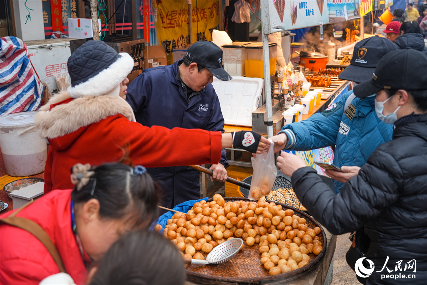 游客購買路邊現做現賣的麻圓。 人民網 涂詩軒攝