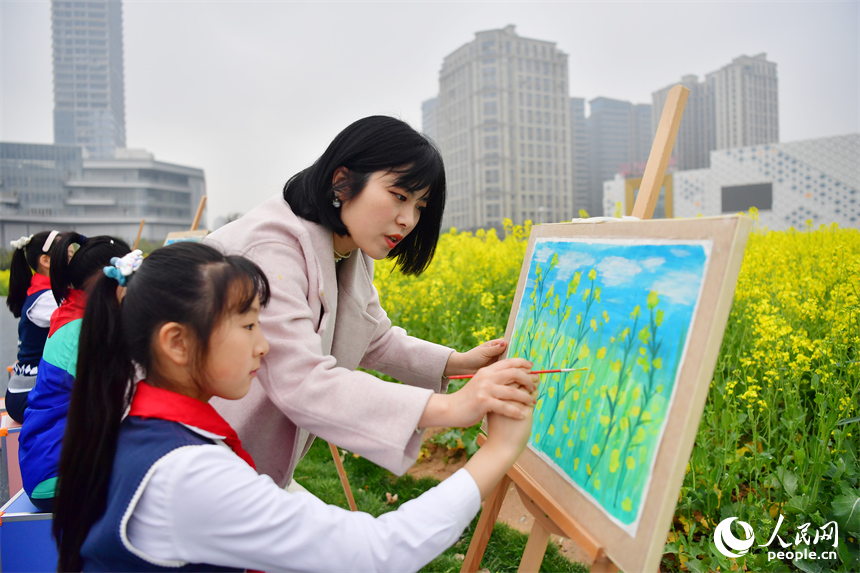 老師在花海中指導學生作畫，描繪春天的顏色。人民網記者 時雨攝