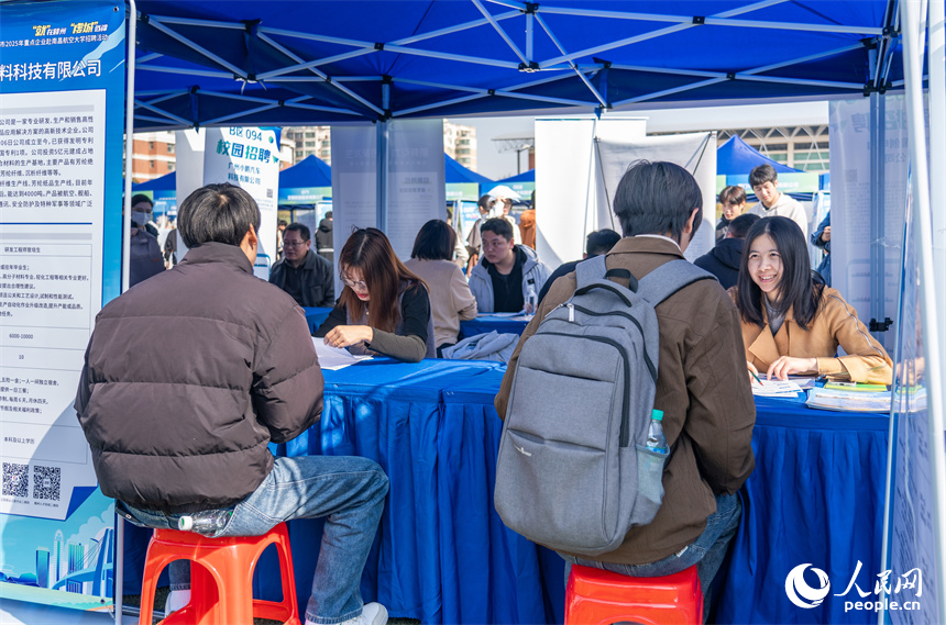 招聘会现场，招聘企业正在了解学生情况。人民网 龙楚良摄