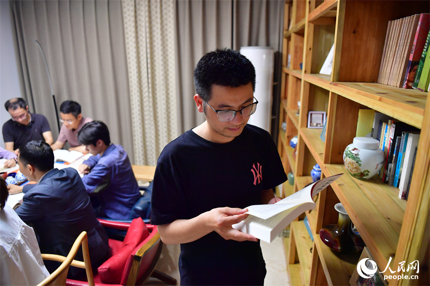 读书会成员在书架旁翻阅自己感兴趣的书籍。人民网记者 时雨摄