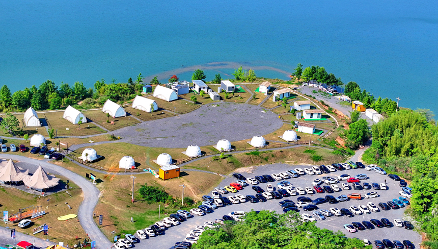 赣州市上犹县的趣野南湖野奢营地，房车帐篷、露营帐篷鳞次栉比，吸引众多游客驱车前来游玩，畅享户外露营乐趣。人民网 朱海鹏摄