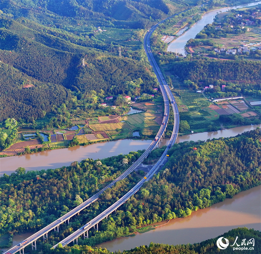 车辆在康大高速江西省大余县黄龙镇境内行驶，公路沿线山清水秀乡村美。人民网 朱海鹏摄