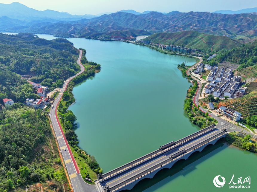 贛州市上猶縣東山鎮，車輛在環湖公路行駛，沿線水清岸綠景美春意濃。人民網 朱海鵬攝
