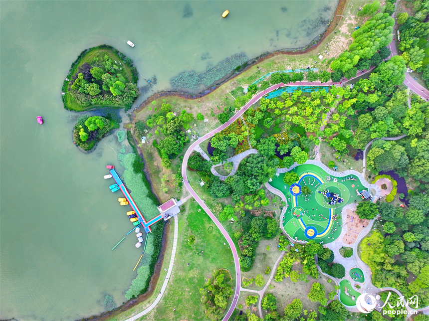 贛州市中心城區的一處公園裡，家長帶著孩子在兒童游樂園內游玩，樂享親子時光。人民網 朱海鵬攝