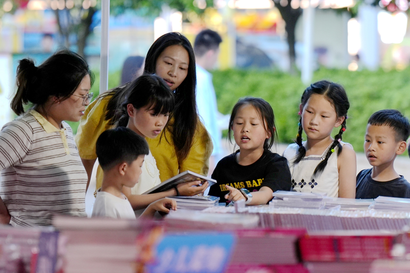 上高县万象广场，市民正在书摊前挑选购买各类图书。陈旗海摄