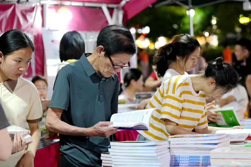 上高县万象广场，市民正在书摊前挑选购买各类图书。陈旗海摄