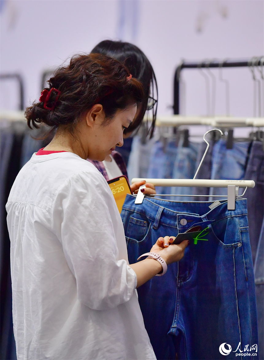 2025中國(南昌)國際服裝服飾博覽會在紅谷灘區舉行。圖為採購商正在挑選服飾產品。人民網記者 時雨攝