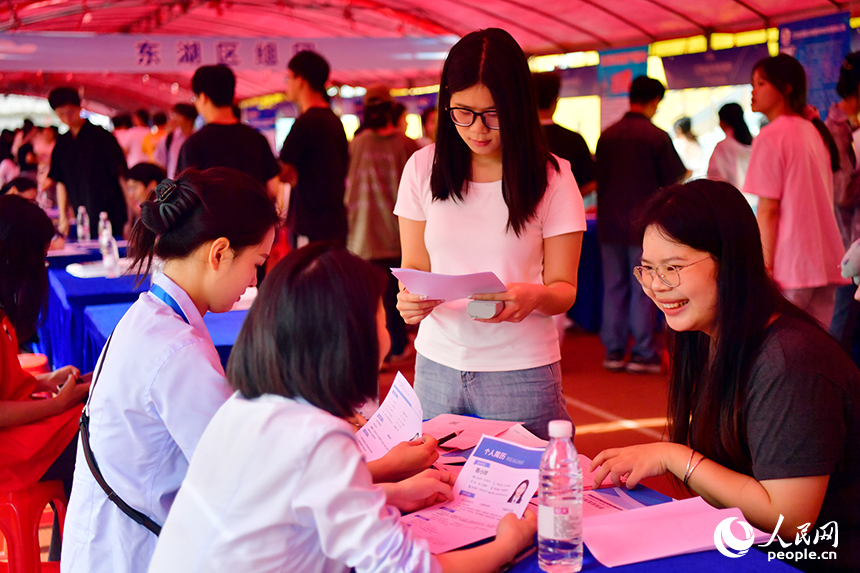 “國聘行動”現場，高校畢業生正在跟企業招聘人員交談。人民網記者 時雨攝