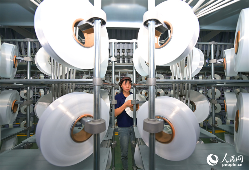瑞金市的一家化纖紡織企業，工人在生產線上趕制出口東南亞國家的產品訂單。人民網 朱海鵬攝
