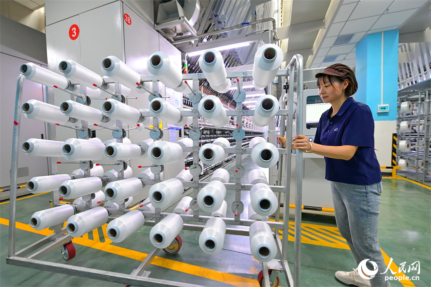 瑞金市的一家化纖紡織企業，工人在生產線上趕制出口東南亞國家的產品訂單。人民網 朱海鵬攝