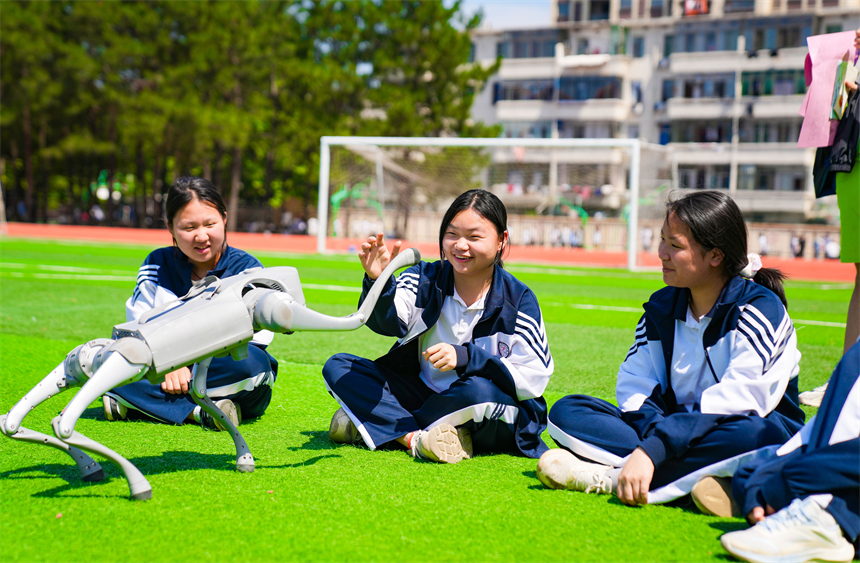 大课间活动时，学生们正在与机器狗进行“人机互动”。郭昊摄