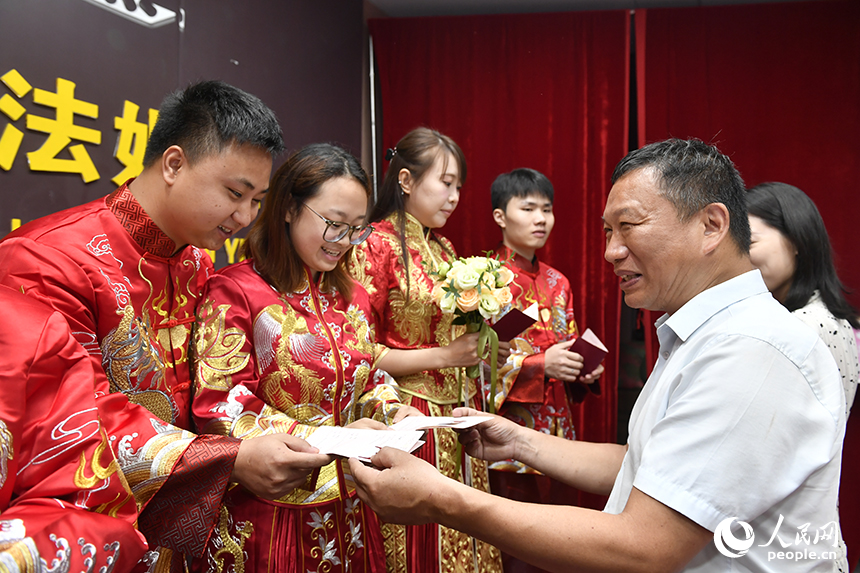 婚姻登记中心工作人员为新人们颁发结婚证。人民网记者 时雨摄