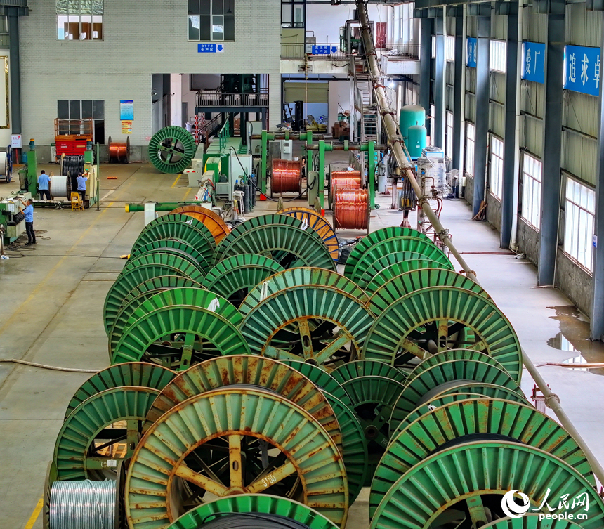 瑞金市經濟開發區的一家電線電纜企業智能制造車間內，工人在生產線上趕制出口的銅線訂單產品。人民網 朱海鵬攝