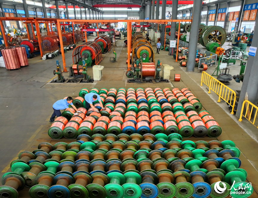 瑞金市经济开发区的一家电线电缆企业智能制造车间内，工人在生产线上赶制出口的铜线订单产品。人民网 朱海鹏摄