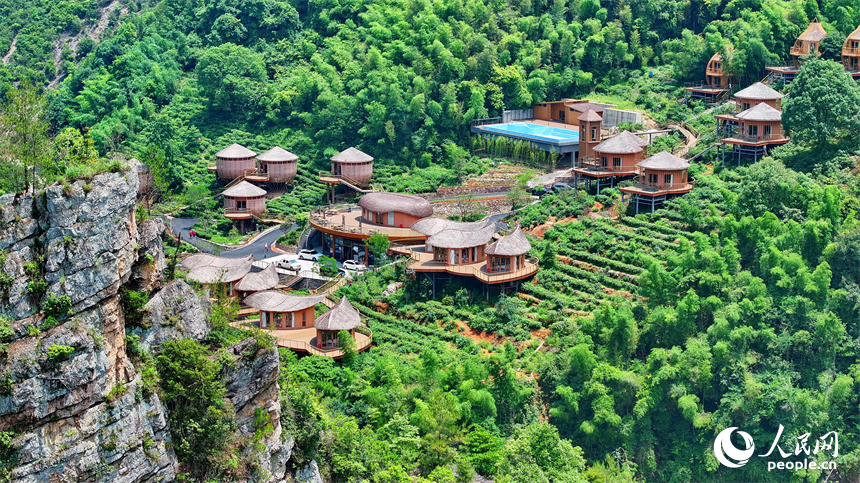 赣州市上犹县梅水乡园村村的一处露营基地，一栋栋民宿小木屋与青山、竹林、茶园相映衬。人民网 朱海鹏摄
