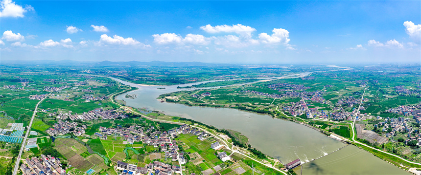 2025年6月4日，在江西省抚州市临川区上顿渡镇周家村，水量充沛的河流与农田、民居相映成趣。郭昊摄