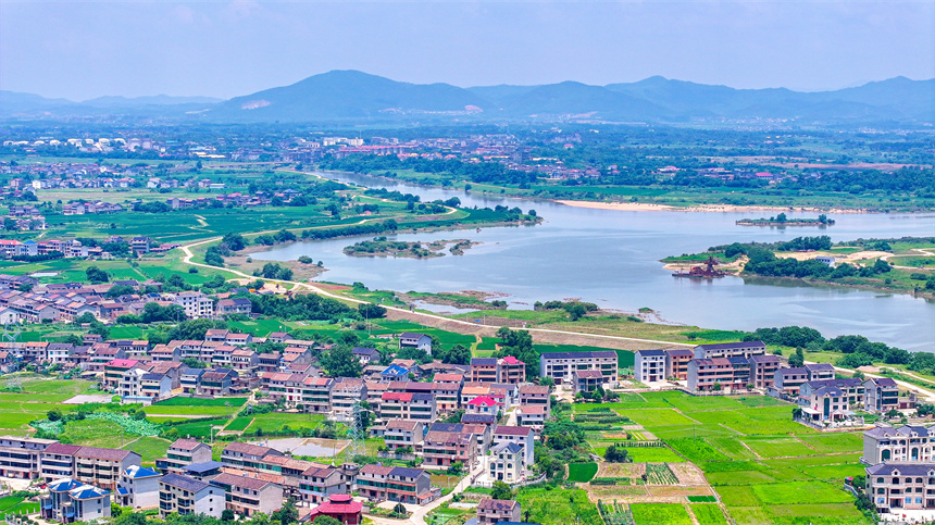2025年6月4日，在江西省抚州市临川区上顿渡镇周家村，水量充沛的河流与农田、民居相映成趣。郭昊摄