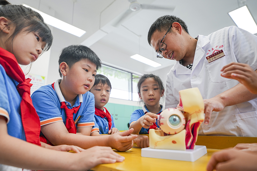 医生在向学生讲解眼睛的构造。谢东摄