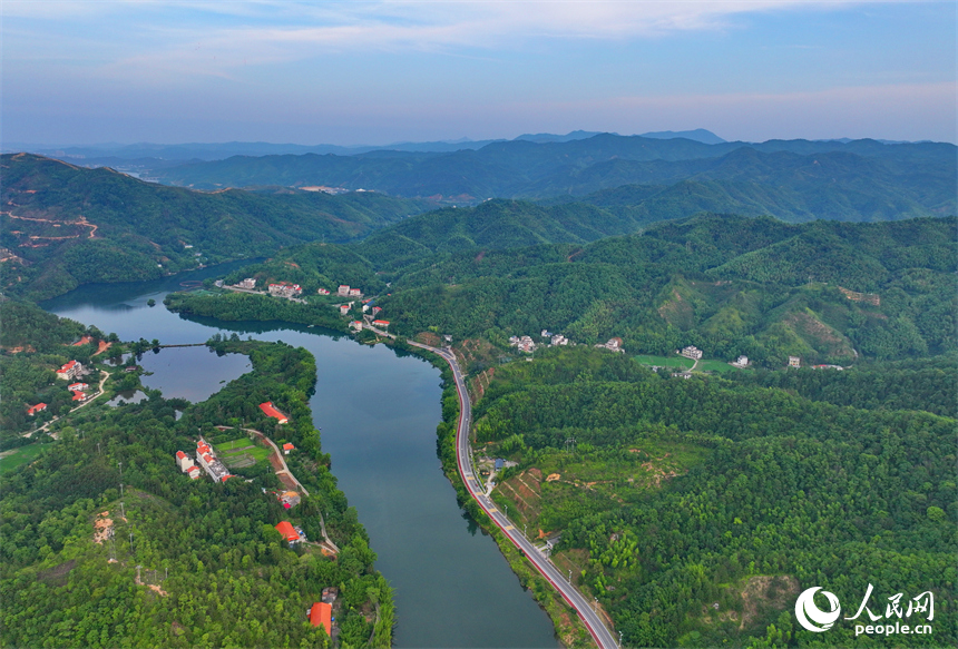 赣州市上犹县陡水镇，车辆在农村公路上行驶，沿线水清景美绿意浓。人民网 朱海鹏摄