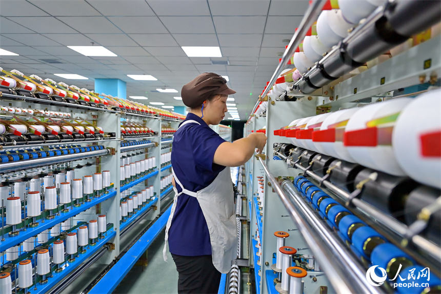 江西申華新材料有限公司5G智慧車間內，工人在加工錦綸紡絲新材料產品。人民網 朱海鵬攝