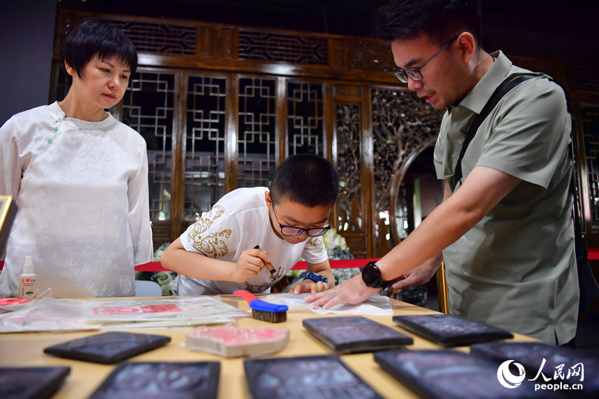 一名小朋友现场体验非遗技艺。人民网记者 时雨摄