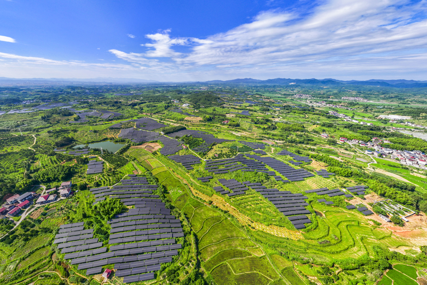 南豐縣桑田鎮古城村,鱗次櫛比的太陽能光伏板與青山綠樹、村庄田園相互映襯,大地猶如披上藍色“外衣”。謝東攝