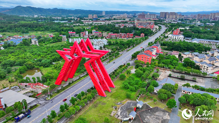 瑞金市葉坪鎮葉坪村，“勝利之門”地標蔚為壯觀，周邊鱗次櫛比的房屋與郁郁蔥蔥的田園、山丘、樹木相映成景。人民網 朱海鵬攝