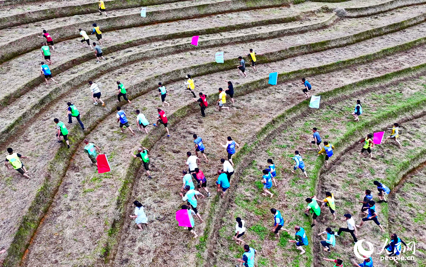 崇义县上堡乡上堡梯田，村民在参与乡村趣味运动会梯田攀爬比赛。人民网 朱海鹏摄