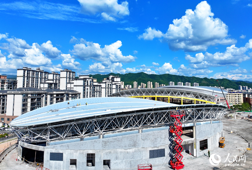 赣州市石城县西城体育中心项目建设现场，工人在安装体育馆钢结构屋面网架和顶棚。人民网 朱海鹏摄