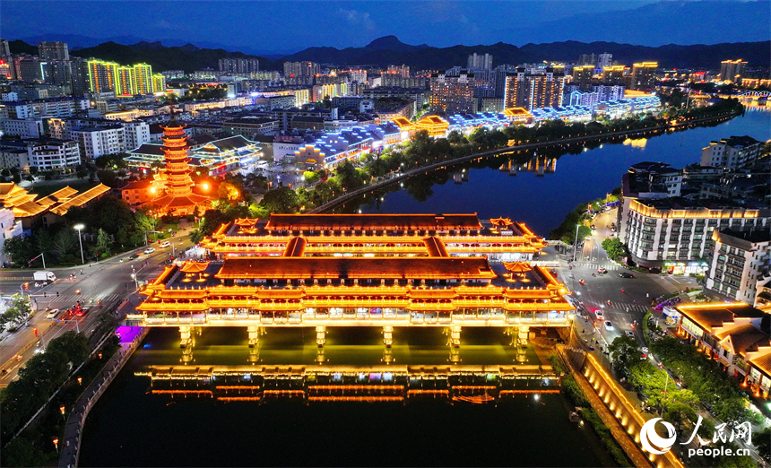 贛州市石城縣琴江鎮琴江兩岸古建筑燈光璀璨，許多游客前來觀賞古鎮夜景，品嘗夜市美食。人民網 朱海鵬攝