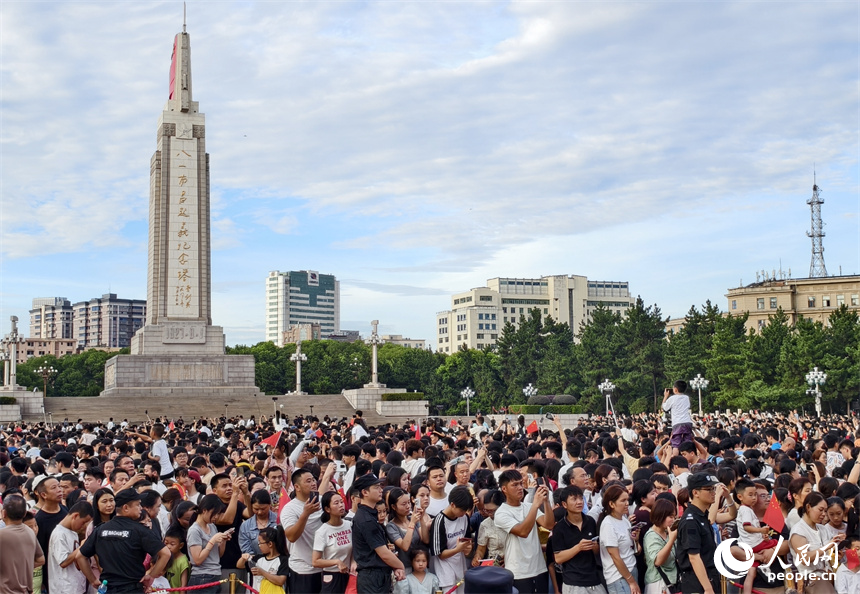 八一广场上人山人海，大家共同见证鲜艳的国旗和朝阳一同冉冉升起。人民网记者 时雨摄