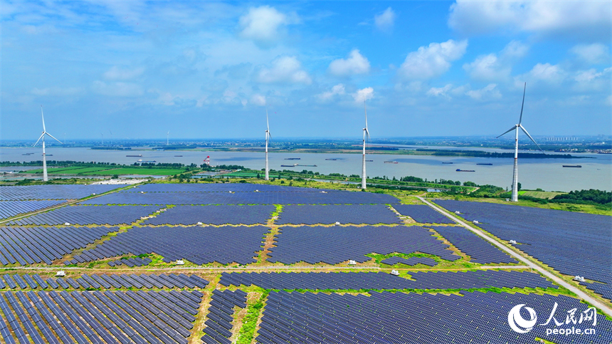 九江市彭澤縣帽子山風光電站，連片的光伏發電板與風力發電機組相得益彰，源源不斷地輸送清潔能源。人民網 朱海鵬攝