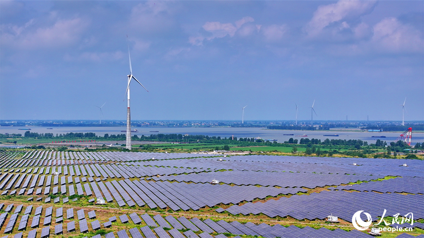 九江市彭澤縣帽子山風光電站，連片的光伏發電板與風力發電機組相得益彰，源源不斷地輸送清潔能源。人民網 朱海鵬攝