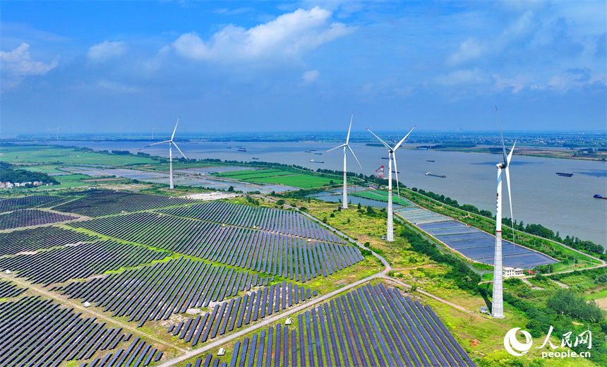 九江市彭澤縣帽子山風光電站，連片的光伏發電板與風力發電機組相得益彰，源源不斷地輸送清潔能源。人民網 朱海鵬攝
