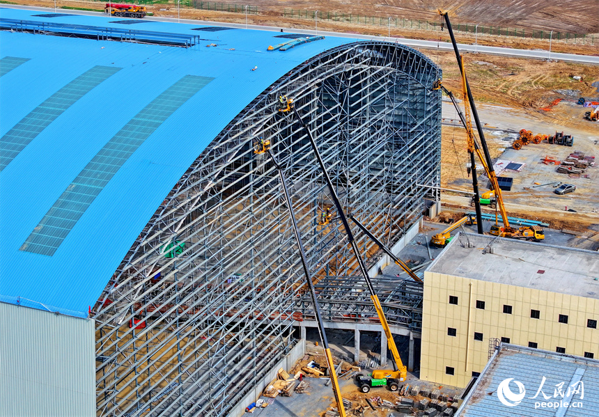 建设者们冒着高温在高空进行货棚挡板安装作业。人民网 朱海鹏摄