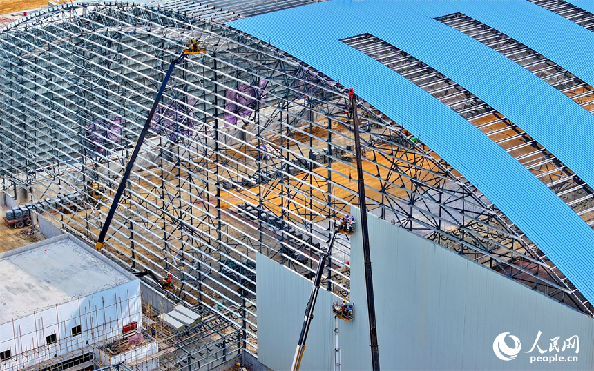 建设者们冒着高温在高空进行货棚挡板安装作业。人民网 朱海鹏摄