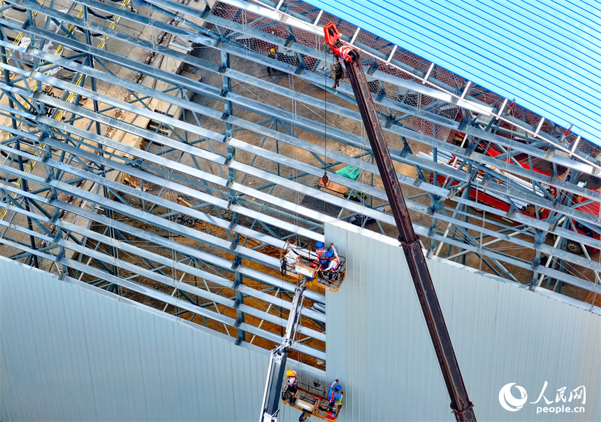 建设者们冒着高温在高空进行货棚挡板安装作业。人民网 朱海鹏摄