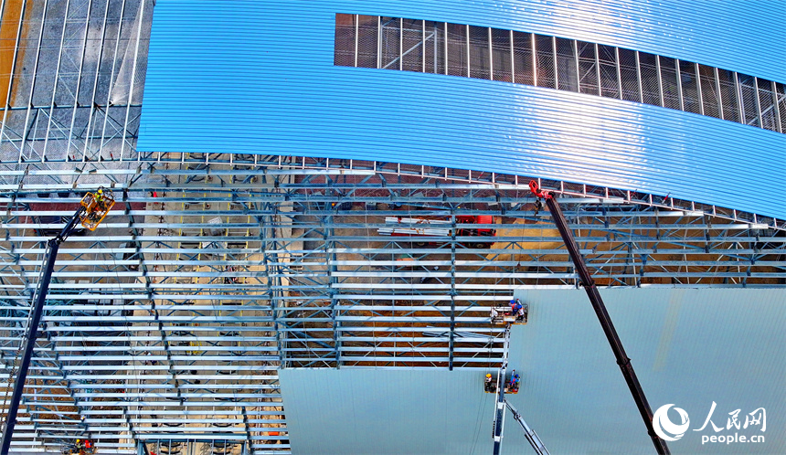 建设者们冒着高温在高空进行货棚挡板安装作业。人民网 朱海鹏摄