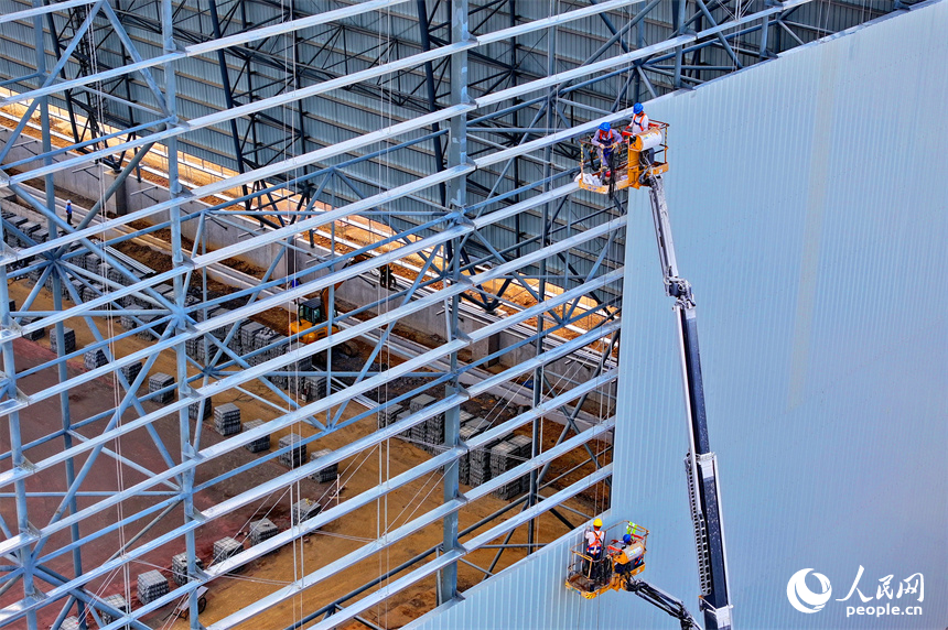建设者们冒着高温在高空进行货棚挡板安装作业。人民网 朱海鹏摄