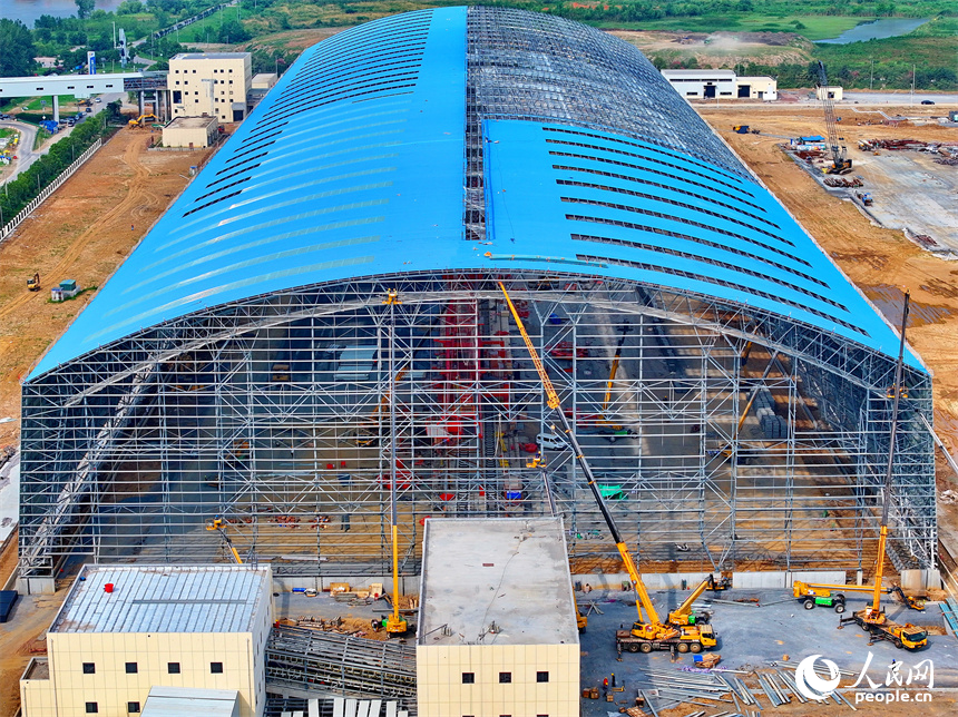 建设者们冒着高温在高空进行货棚挡板安装作业。人民网 朱海鹏摄