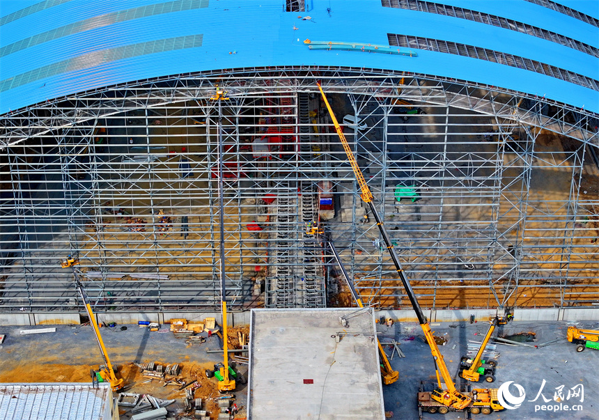 建设者们冒着高温在高空进行货棚挡板安装作业。人民网 朱海鹏摄