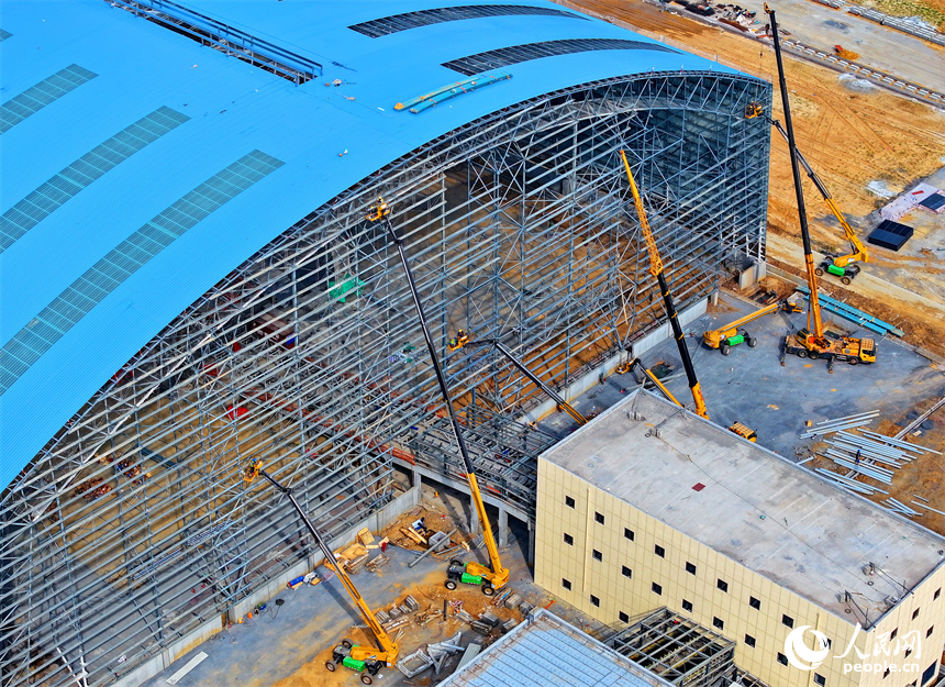 建设者们冒着高温在高空进行货棚挡板安装作业。人民网 朱海鹏摄