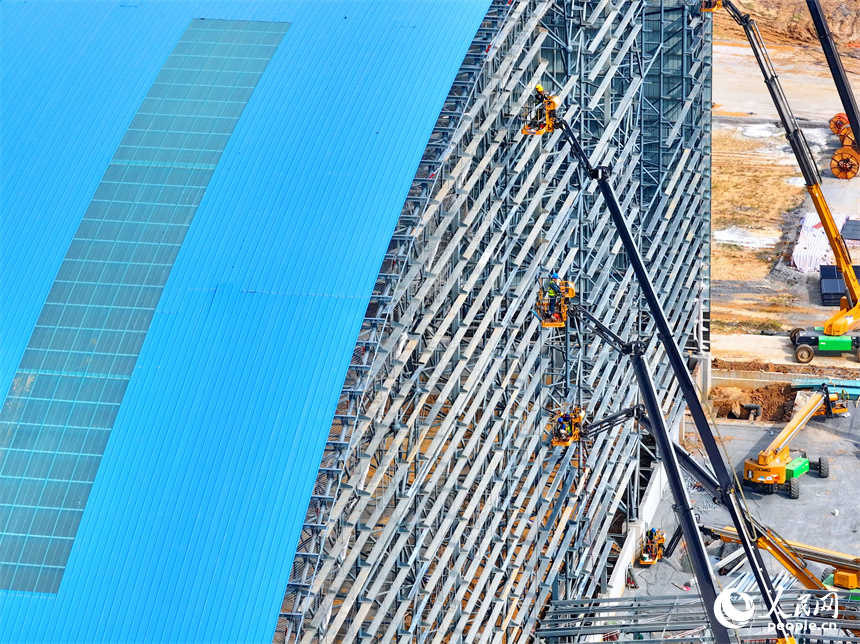 建设者们冒着高温在高空进行货棚挡板安装作业。人民网 朱海鹏摄