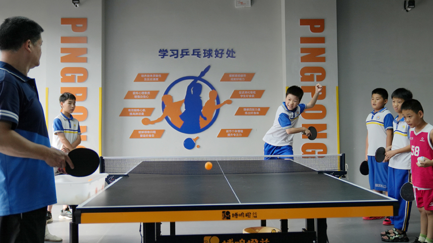 孩子们正在老师的指导下练习乒乓球扣杀技术。陈旗海摄