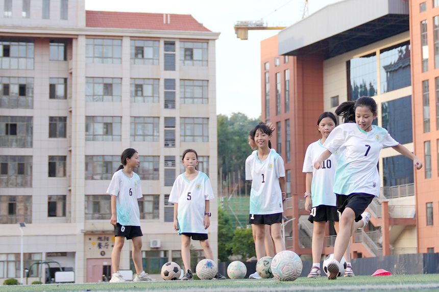 孩子们正在老师的指导下练习足球定点射门。陈旗海摄