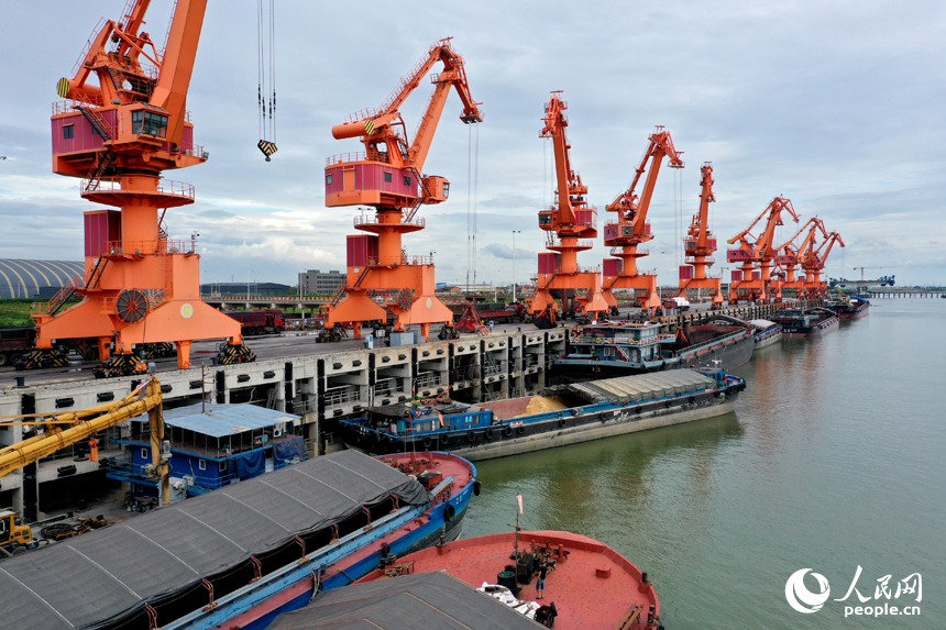 赣江南昌县水域的姚湾综合码头上，龙门吊正在装卸货船上的货物。人民网记者 时雨摄