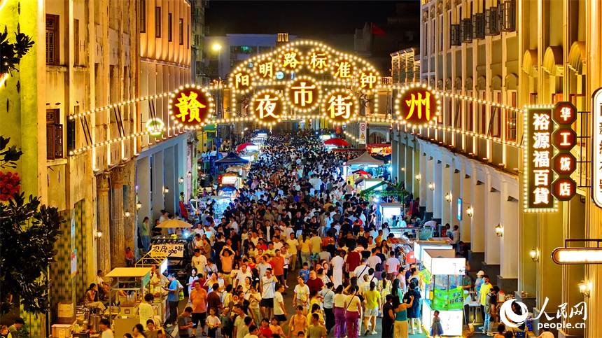 赣州市阳明路标准钟夜市街，人头攒动、熙熙攘攘，许多游客在逛夜市、吃小吃。人民网 朱海鹏摄