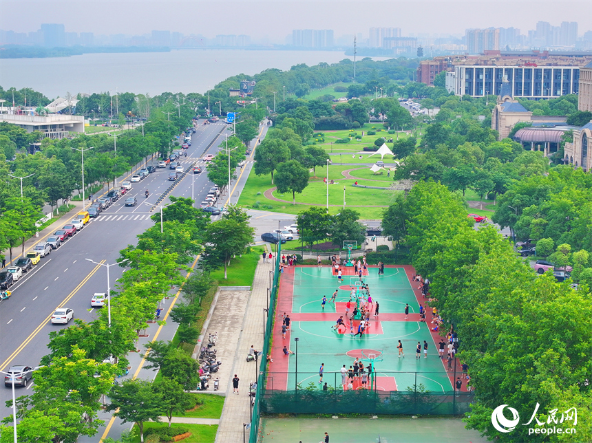 南昌高新區氣膜體育中心室外球場，市民在打網球、打籃球，享受運動健身的樂趣。人民網 朱海鵬攝