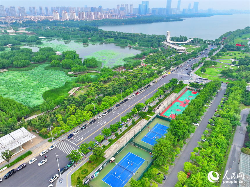 南昌高新區氣膜體育中心室外球場，市民在打網球、打籃球，享受運動健身的樂趣。人民網 朱海鵬攝